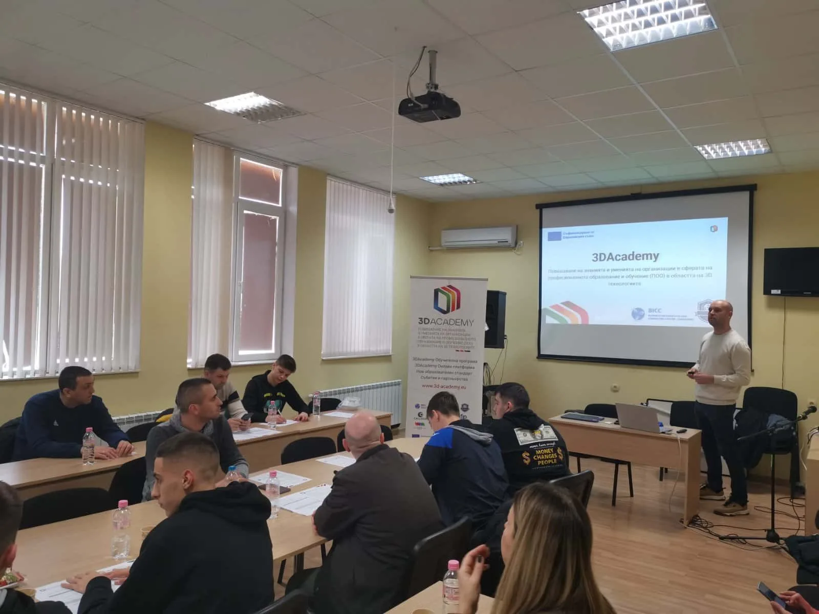 Участници слушат презентация в учебна зала.